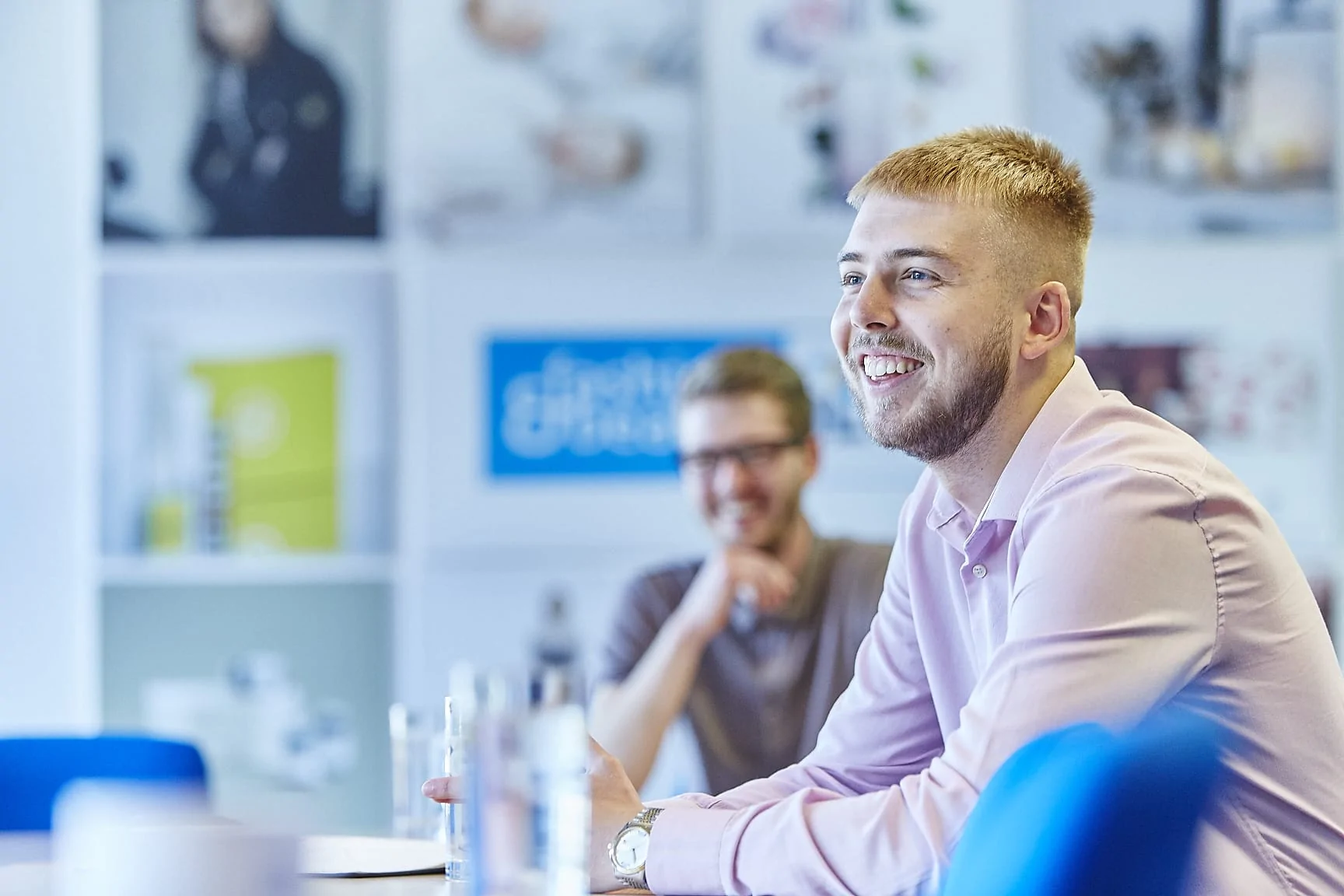 Two team members smiling in an office