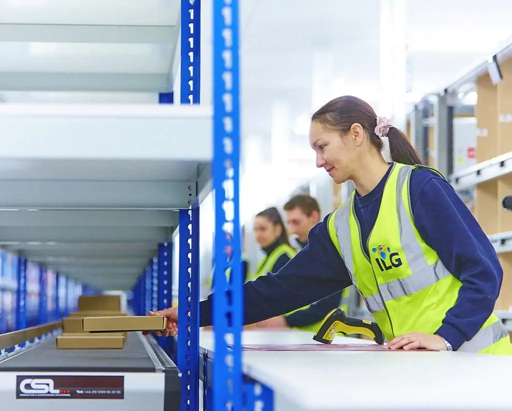 Woman sorting packages in a fulfilment warehouse