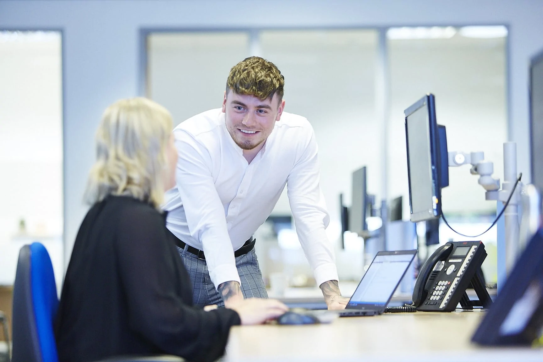 Office team member talking to a colleague