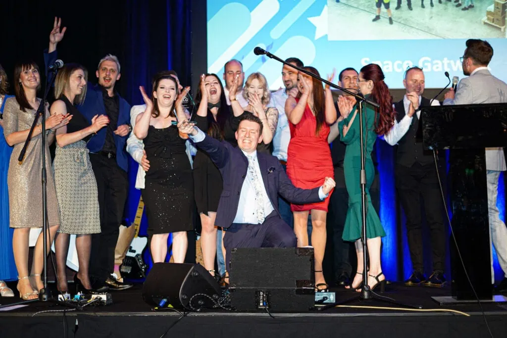 A large group of team members celebrating on stage